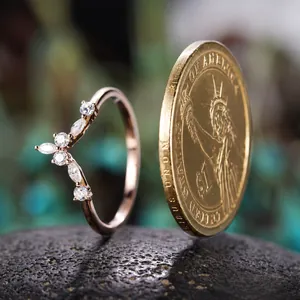 Nahaufnahme von roségoldenem V-Ring mit Marquise-Zirkonia und US-Münze zum Größenvergleich