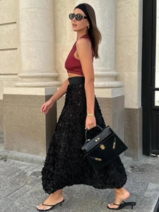 Detailed close-up of 3D floral texture on black A-line evening maxi skirt during movement