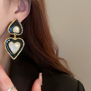 Detaillierte Nahaufnahme von Vintage Herzohrringen mit Strasssteinen am Modell