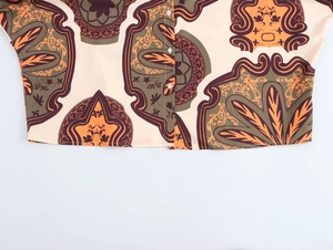 Detail of printed resort style shirt hem with vintage patterns and white buttons
