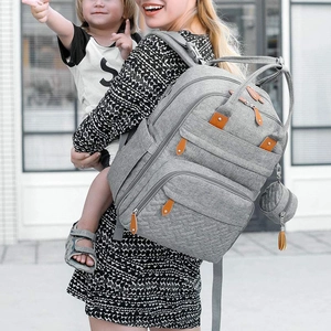 Close-up of gray waterproof mommy backpack with brown leather pulls and hanging tassel