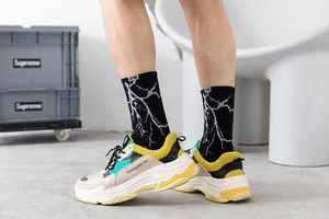 Style streetwear avec baskets chunky beiges et chaussettes à motif d'éclair blanc