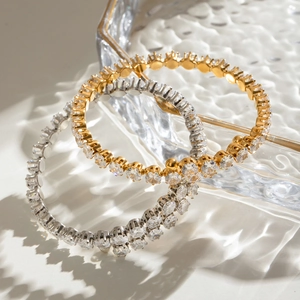 Detail of luxury gold and silver stainless steel bangles with white cubic zirconia crystals