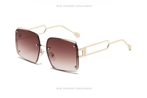 Detail view of gold metal square sunglasses with hollow geometric temple design and gradient lenses