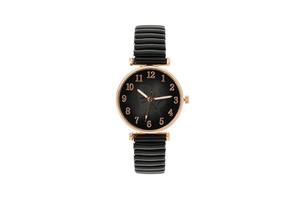 Detail of rose gold case and black dial with leaf pattern on elastic strap watch