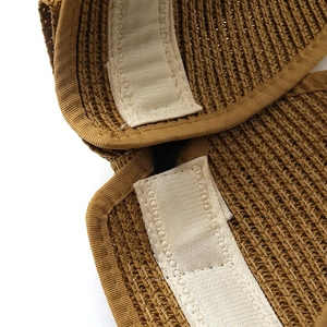 Detail of adjustable velcro strap and elastic band inside brown straw sun visor hat