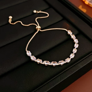Close-up of golden marquise crystal bracelet with adjustable pull chain on black leather box