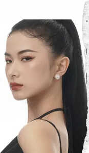 Close-up of irregular textured silver stud earrings on model with high ponytail