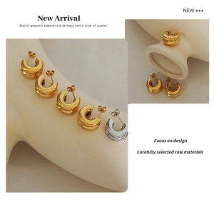 Detail of vintage C-shaped double-layer earrings with vertical textures in gold and silver