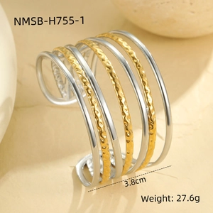 Detail view of a 3.8cm wide geometric layered open cuff with gold and silver wave textures