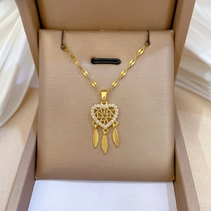 Dettaglio della collana acchiappasogni dorata con pendente a cuore e piume pendenti