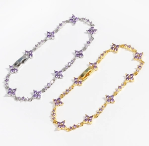 Macro detail of clover bracelets in gold and silver finish with purple zircon stones