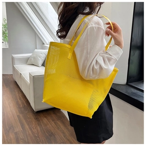 Yellow mesh tote bag shown on model highlighting the large capacity and beach-ready style
