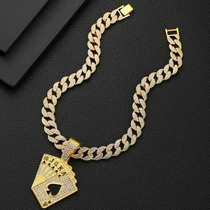 Détail d'une chaîne cubaine dorée avec pendentif de poker royal flush en strass