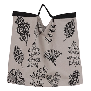 Minimalist beige canvas tote bag with black botanical leaf patterns and sturdy handles