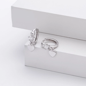 Detail of silver heart hoop earrings with sparkling cubic zirconia on a white stand