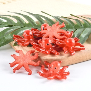 Realistic PVC octopus keychain with red textured surface on a wooden display board