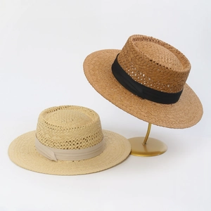 Detailed weave texture of straw boater hats in beige and brown with grosgrain ribbons