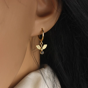 Golden hoop earring with flying bird pendant and black zircon stone for women
