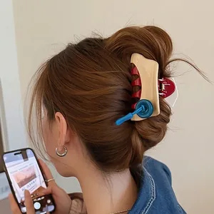 Chic button shark hair claw clip in beige and red shown on a model hairstyle