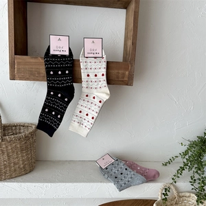 Détail de quatre paires de chaussettes en coton avec jacquard cœur et étoile sur bois