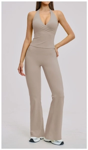 Detail of high-waisted flared yoga pants and halter wrap sports top in khaki matte fabric