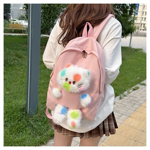 Zaino in nylon rosa con gatto di peluche a pois mostrato in un ambiente all'aperto