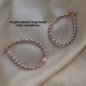 Detail of purple freshwater pearl bracelets with gold clasps on silk background