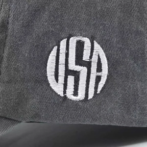 Detailed macro view of white circular USA 3D embroidery on a dark cotton baseball cap