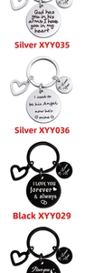 Close-up of engraved stainless steel heart and round pendants in silver and black metal