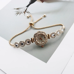 Detail of floral gold quartz watch with sparkling rhinestones and adjustable box chain