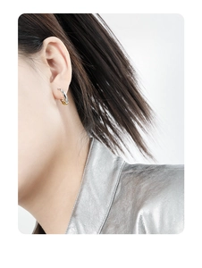 Detail showing two-tone geometric S925 sterling silver C-shaped stud earrings on ear
