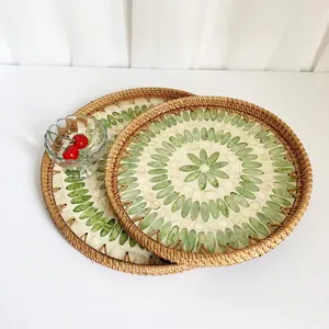 Detail of round handmade rattan trays with inlaid shell patterns in a two-piece set