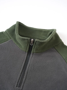 Detail of olive green high collar fleece pullover with contrast dark grey stitching