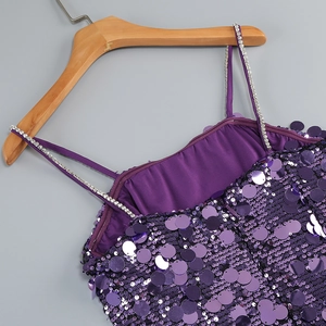 Makrodetail eines lila Paillettenkleides mit schimmerndem Stoff und Strass-Trägern