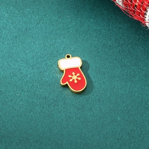 Detail of red enamel Christmas glove pendant with golden snowflake and white cuff
