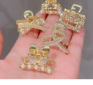 Makro-Detail eines 5-teiligen goldenen Haarspangen-Sets mit Perlen und Strasssteinen