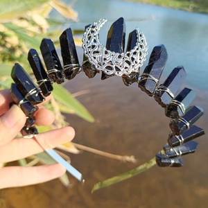 Detail of black raw crystal crown with a silver crescent moon on a metal headband