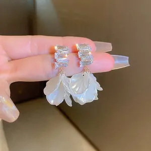 Gros plan détaillé de boucles d'oreilles fleurs françaises avec pétales et zircons