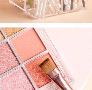 Detailed macro shot of warm-toned eyeshadow textures with a professional makeup brush
