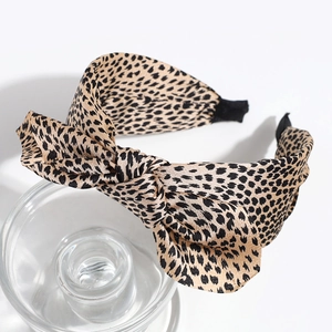 Close-up of leopard print headband with a large bow on a transparent glass display