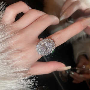 Macro shot of a vintage gold-plated oval zircon ring with halo setting on a luxury background