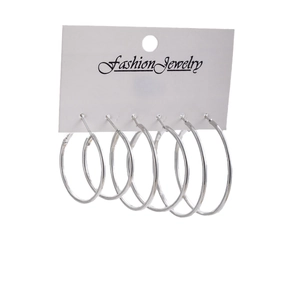 Set of three pairs of silver minimalist hoop earrings on white fashion jewelry card