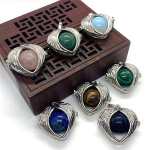Close-up of heart-shaped silver lockets with various colorful gemstone spheres inside