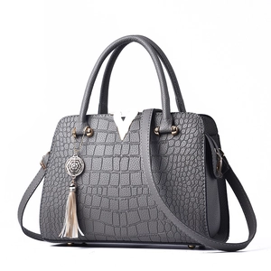Gray crocodile texture handbag with top handle, adjustable strap, and metal V-buckle