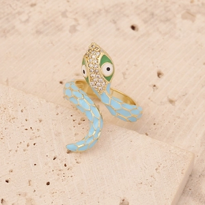 Macro detail of gold snake ring with light blue enamel and sparkling crystal head