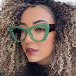 Fashion cat-eye sunglasses with green frames and tortoiseshell temples on model