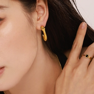 Boucles d'oreilles serpent dorées avec yeux zircons verts et bague pierre noire