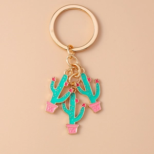 Close-up of golden keychain featuring three green cactus pendants with pink flower details