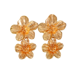 Detailed view of double-layered gold flower earrings with a polished metallic finish